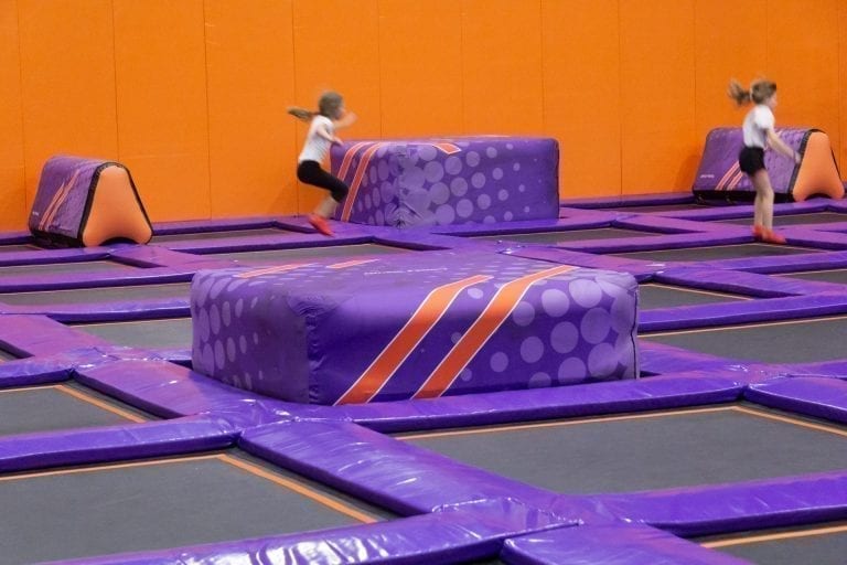Girl jumping towards AirCube in trampoline park