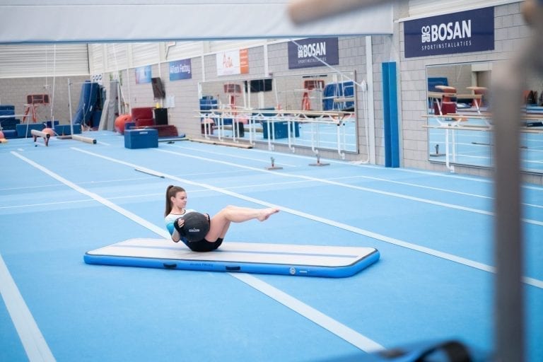 Gymnast training core with the AquaBall on an 4m Air Track AirFloor
