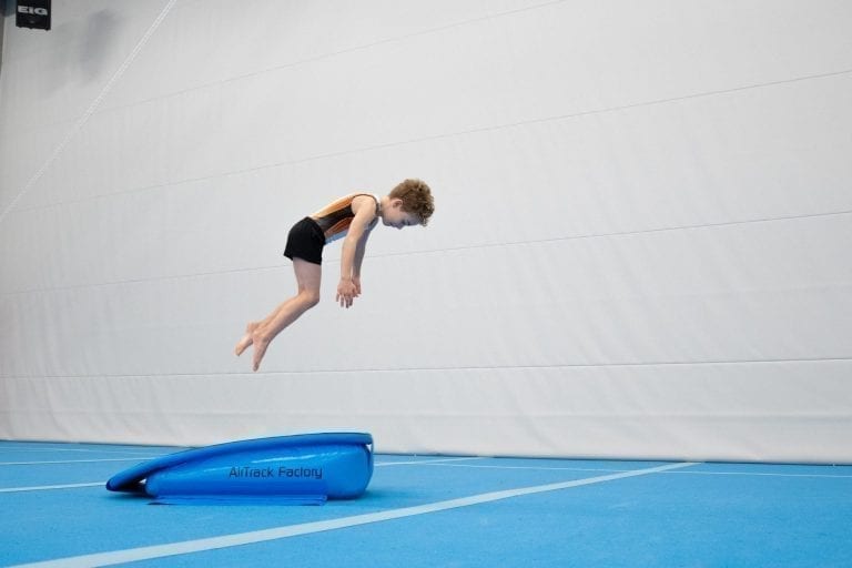 boy-gymnast jumping spring board airboard boost