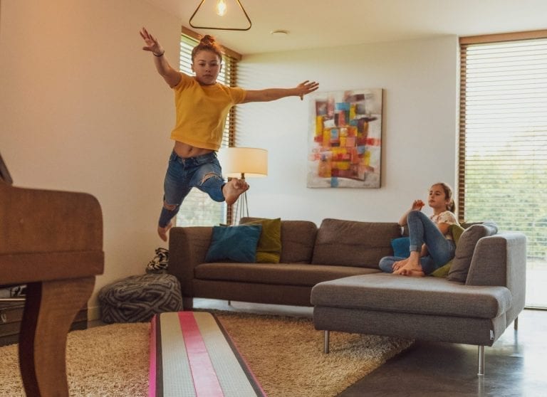 Girl leaping on pink AirBeam in livingroom