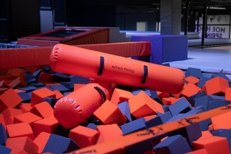 Orange inflatable BattleBeams in foam pit