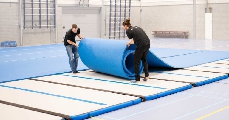 2 coaches setting up the inflatable competition floor