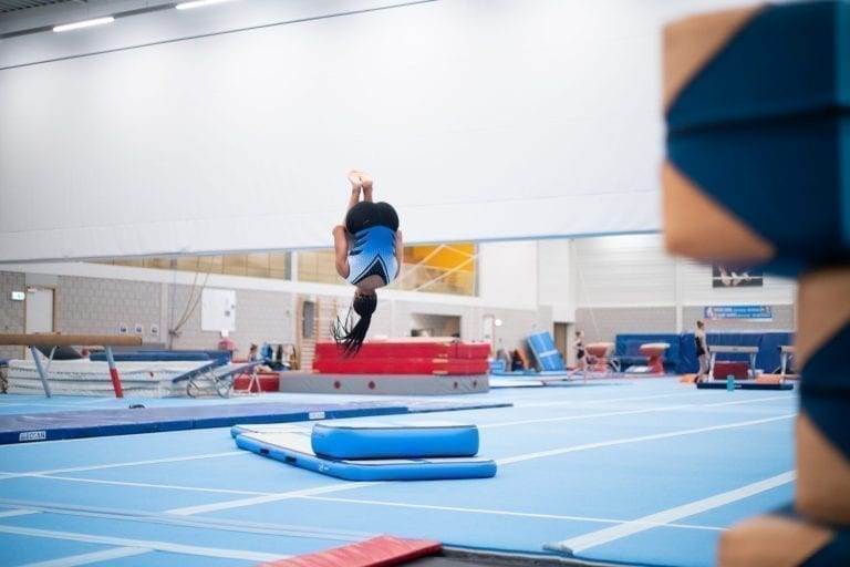 Girl gymnast jumping high on inflatable training set 2